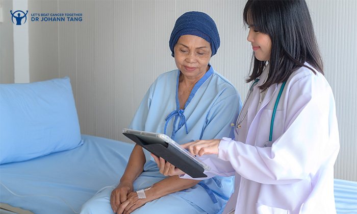 Doctor showing cervical cancer recovery data on tablet to patient.