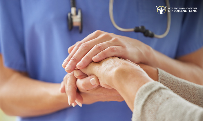 Dr Johann Tang clinic nurse holding female patient’s hand.