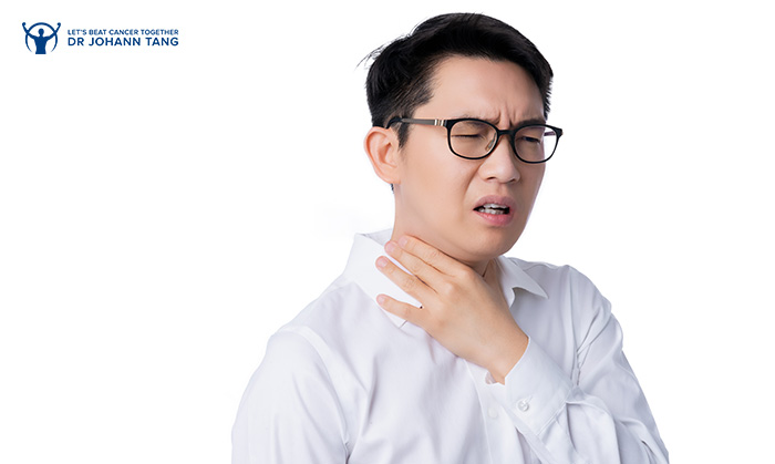 Man experiencing throat discomfort, a potential sign of cancer.
